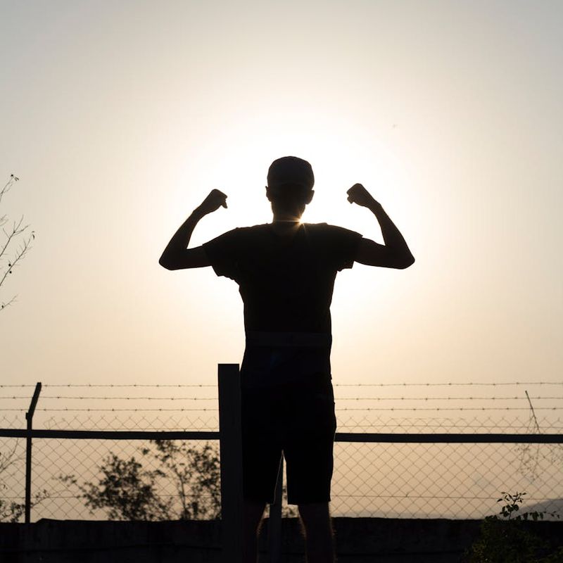 Silhouette of a person stretching during sunrise, full of energy.